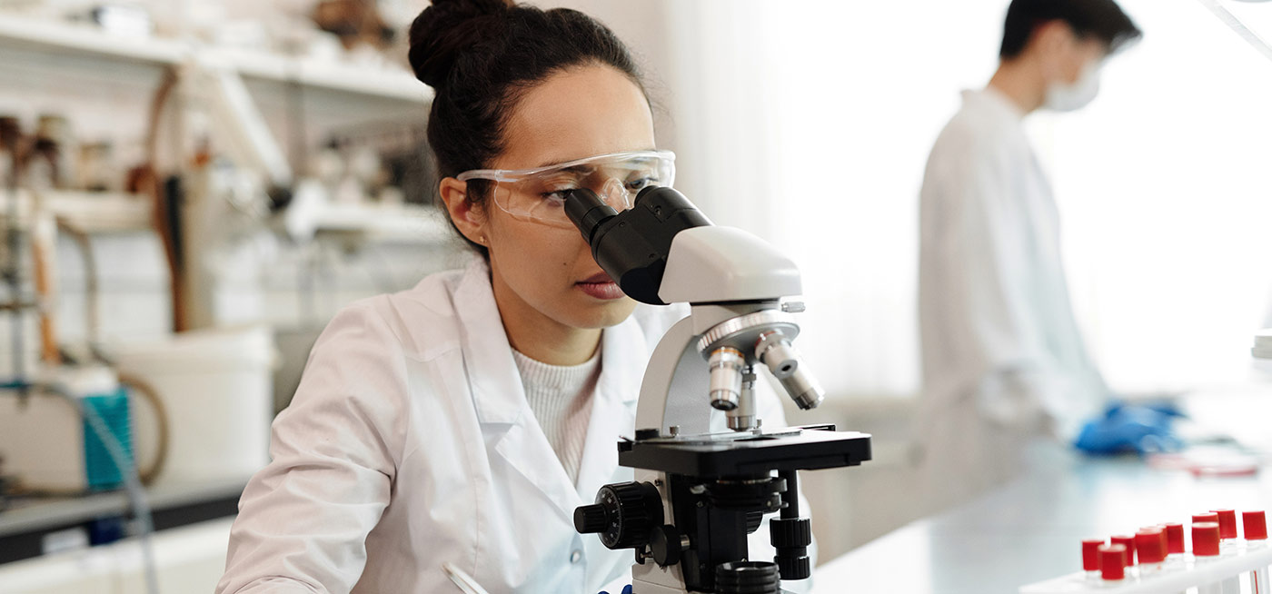 Female using microscope in a laboratory