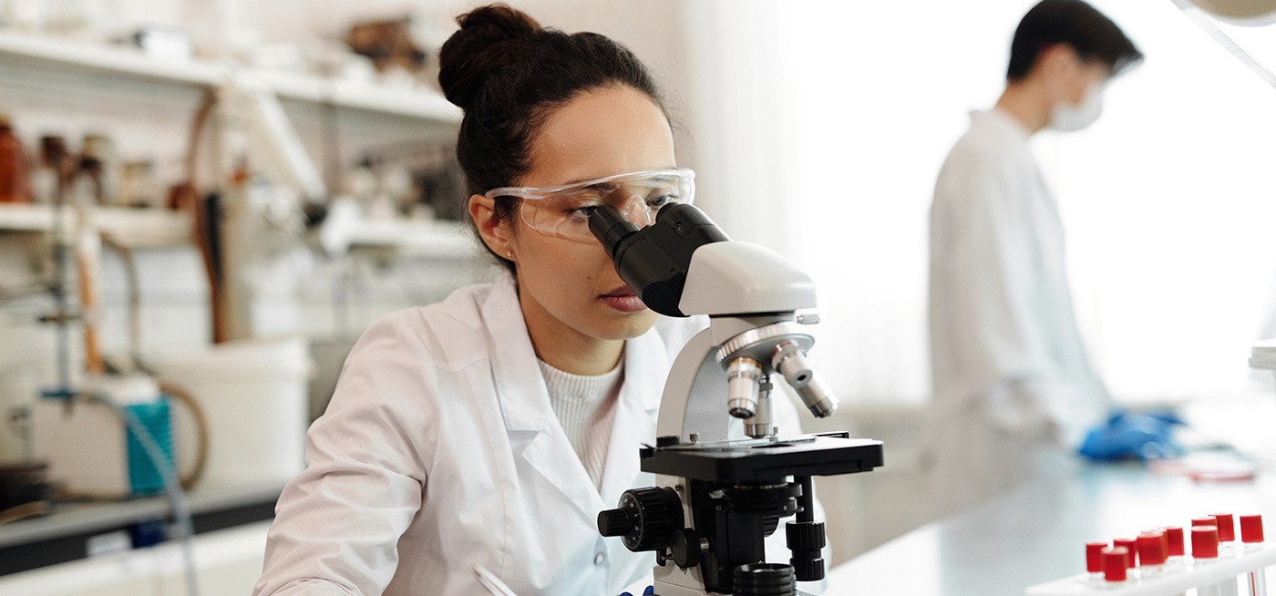 Female using microscope in a laboratory